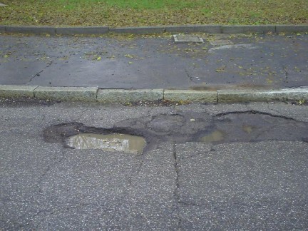 L’asfalto dissestato di una strada milanese