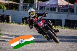 Una supermoto in circuito e la bandiera indiana