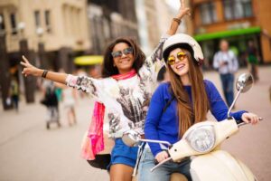 Due ragazze sorridenti su uno scooter