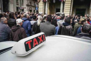 Un Taxi in mezzo alla folla di manifestanti