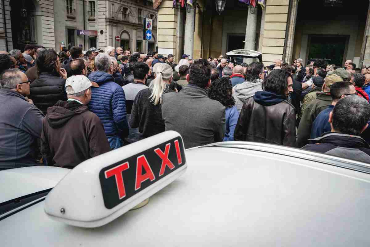 Un Taxi in mezzo alla folla di manifestanti