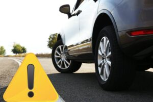 La parte inferiore di un'auto e il disegno di un cartello attenzione