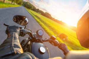 Una persona in moto, sullo sfondo il sole