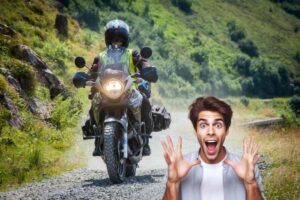 Una persona in sella ad una moto su sterrato e un ragazzo meravigliato