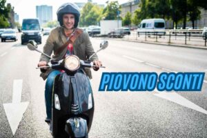 Un uomo su uno scooter e la scritta "piovono sconti"