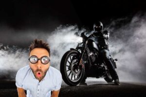 Una persona in sella ad una moto nera tra nuvole di fumo e un uomo stupito