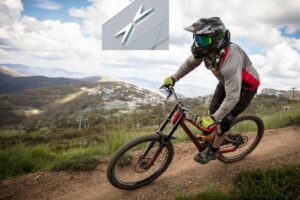 Una persona in mountain bike su un tratto sterrato e il logo della Polestar