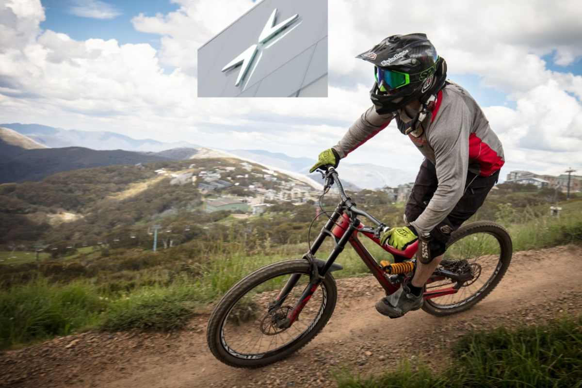 Una persona in mountain bike su un tratto sterrato e il logo della Polestar