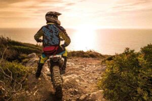 Un motociclista in sella ad una moto da enduro su sterrato