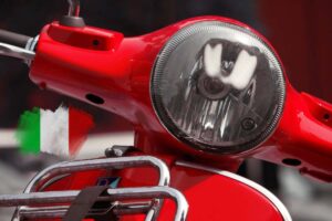 Un dettaglio del frontale della Vespa e una bandiera italiana